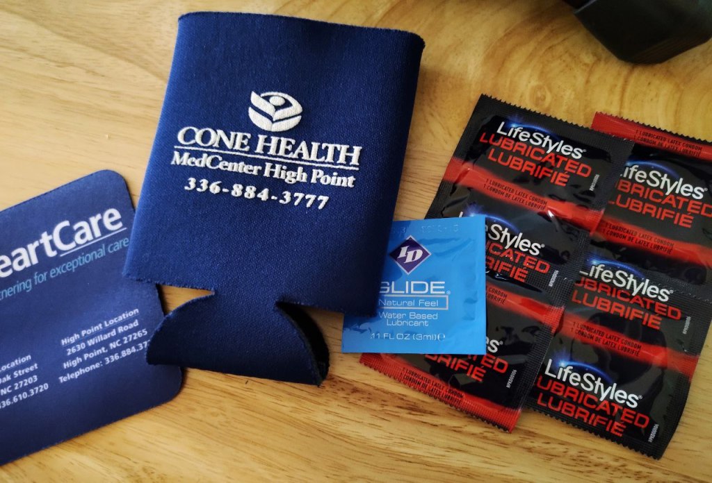 condoms, lube, drink koozie with logo from cone