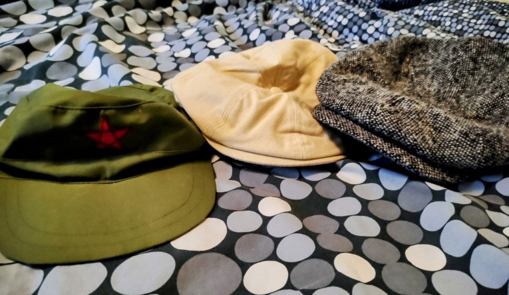 (Image: a teed and a canvas "newsboy," and a green cap with red star)