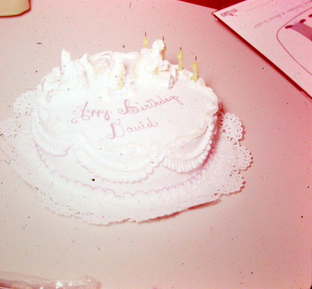 old photo of birthday cake with four candles with icing "Happy Birthday David"