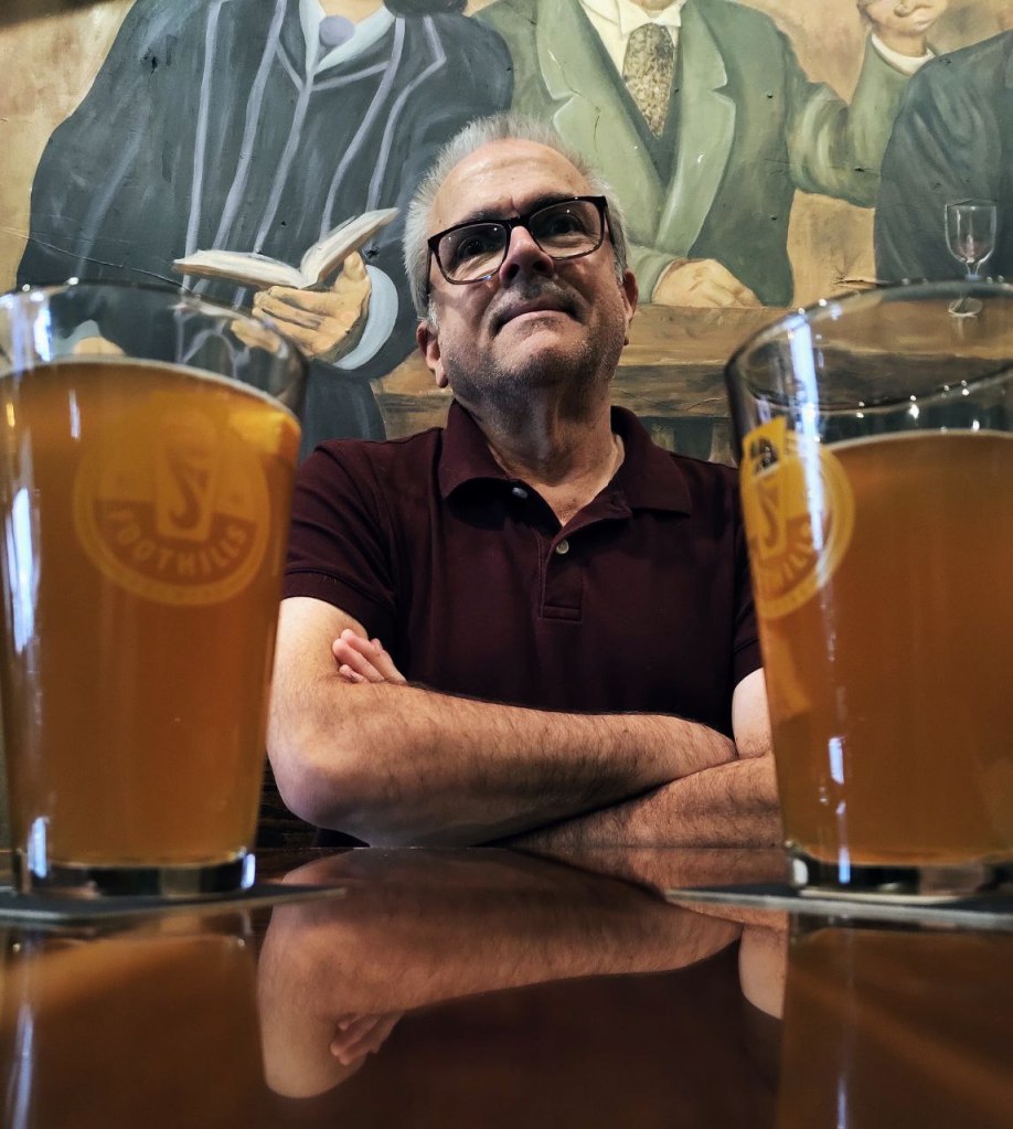 Me posing with two draft beers in pub.