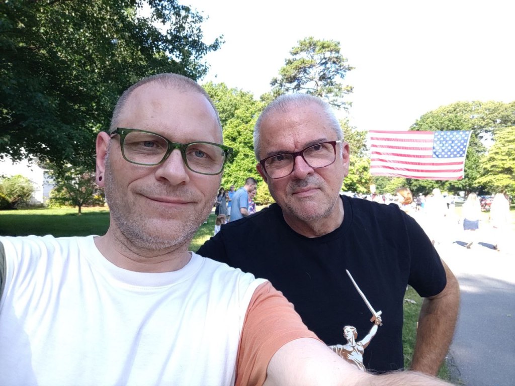 Spouse and I with parade flag in background